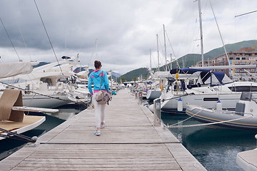 Image showing relaxed young woman walking in marina