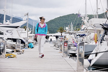 Image showing relaxed young woman walking in marina