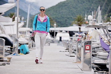 Image showing relaxed young woman walking in marina