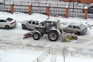 Image showing The tractor sweeps snow on the road.