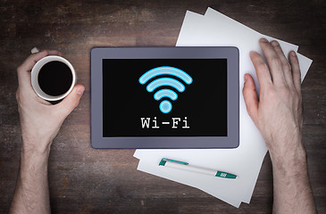 Image showing Tablet with Wi-Fi connection on a wooden desk