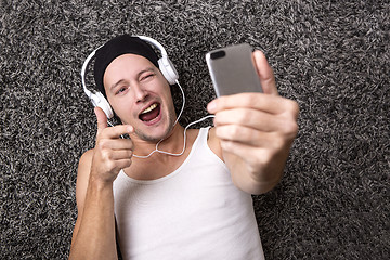 Image showing Attractive man with headphones makes selfie with his mobile