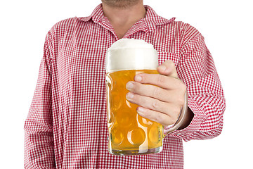 Image showing Man in traditional Bavarian shirt holds mug of beer 