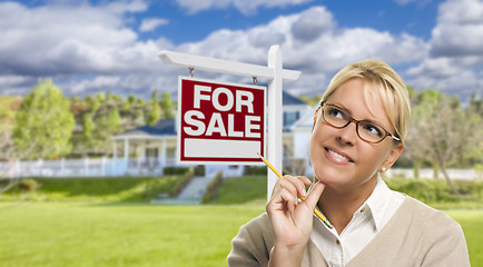 Image showing Young Woman in Front of For Sale Sign and House