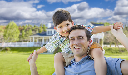 Image showing Mixed Race Father and Son Piggyback in Front of House