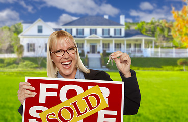 Image showing Excited Woman Holding House Keys and Sold Real Estate Sign