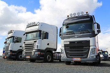 Image showing Row of White Volvo and Scania Trucks