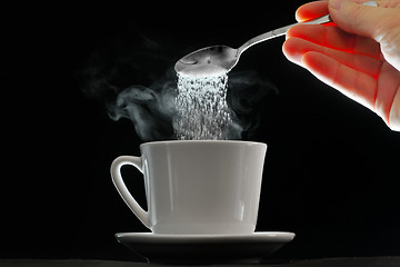 Image showing Coffee cup and pouring sugar spoon