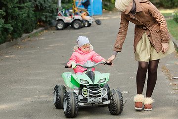 Image showing Little girl riding toy car in park