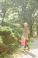 Image showing Beautiful Mother And Baby outdoors. Nature. Beauty Mum and her Child playing in Park together. Outdoor Portrait of happy family. Joy.