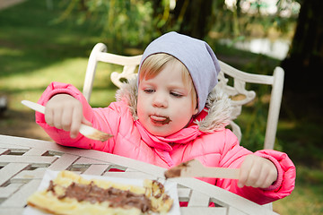 Image showing Child eating waffles with chocolate 
