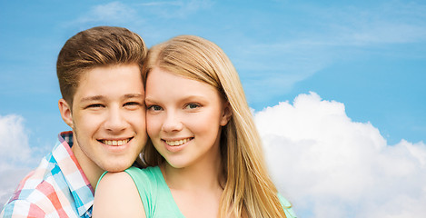 Image showing smiling couple hugging over blue sky background