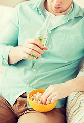 Image showing close up of man with popcorn and beer at home