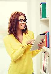 Image showing smiling female student with tablet pc in library