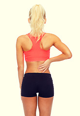 Image showing sporty woman touching her back