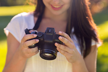 Image showing close up of young girl with photo camera outdoors