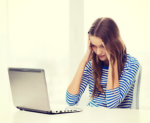 Image showing upset teenage gitl with laptop computer at home