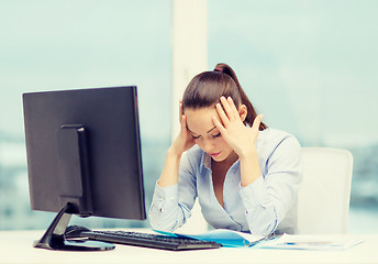 Image showing stressed woman with computer and documents