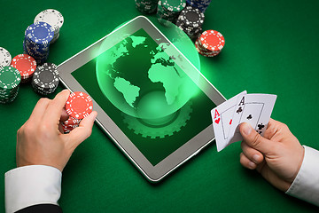 Image showing casino poker player with cards, tablet and chips