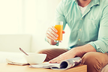 Image showing close up of man with magazine drinking juice