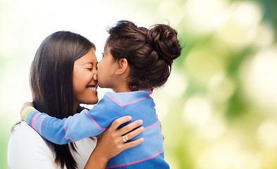 Image showing happy little girl hugging and kissing her mother