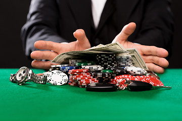 Image showing poker player with chips and money at casino table