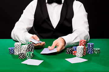 Image showing holdem dealer with playing cards and casino chips