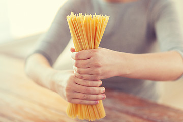 Image showing close up of female hands holding spaghetti pasta