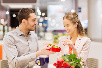 Image showing happy couple with present and flowers in mall