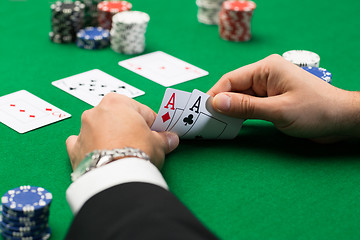 Image showing poker player with cards and chips at casino