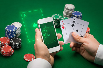 Image showing casino player with cards, smartphone and chips