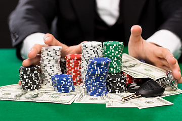 Image showing poker player with chips and money at casino table