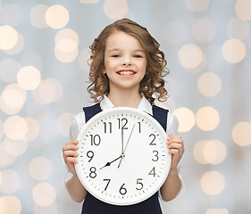 Image showing smiling girl holding big clock