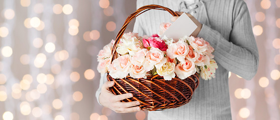 Image showing man holding basket full of flowers and postcard