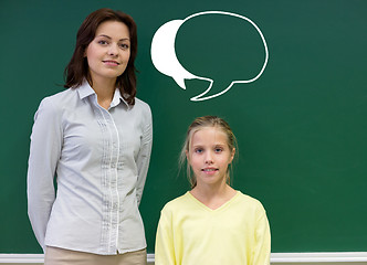 Image showing little school girl with teacher at blackboard