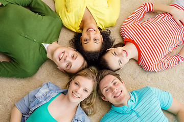 Image showing group of smiling people lying down on floor