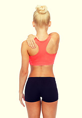 Image showing sporty woman touching her shoulder