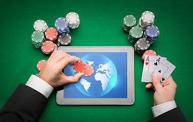 Image showing casino poker player with cards, tablet and chips