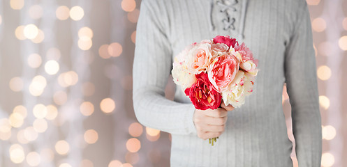 Image showing close up of man holding flowers