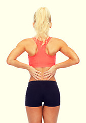 Image showing sporty woman touching her back