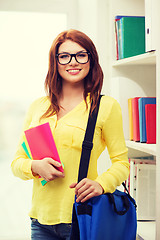 Image showing smiling female student with bag and notebooks