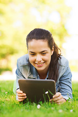 Image showing smiling young girl tablet pc lying on grass