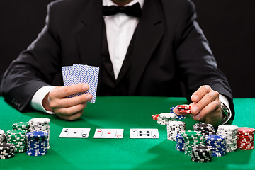 Image showing poker player with cards and chips at casino