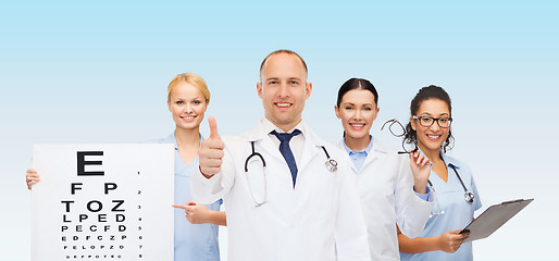 Image showing group of smiling doctors with eye chart