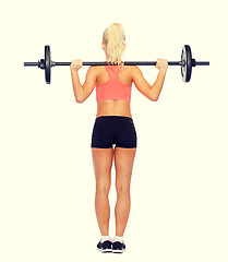 Image showing sporty woman exercising with barbell from the back