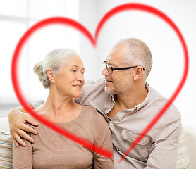 Image showing happy senior couple hugging on sofa at home