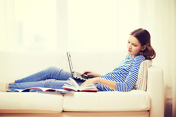 Image showing smiling teenage girl with laptop computer at home