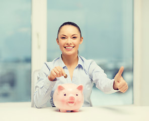 Image showing smiling woman with piggy bank and cash money