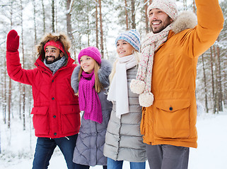 Image showing group of friends waving hands in winter forest