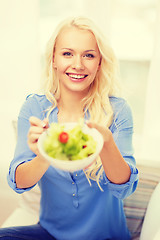 Image showing smiling young woman with green salad at home